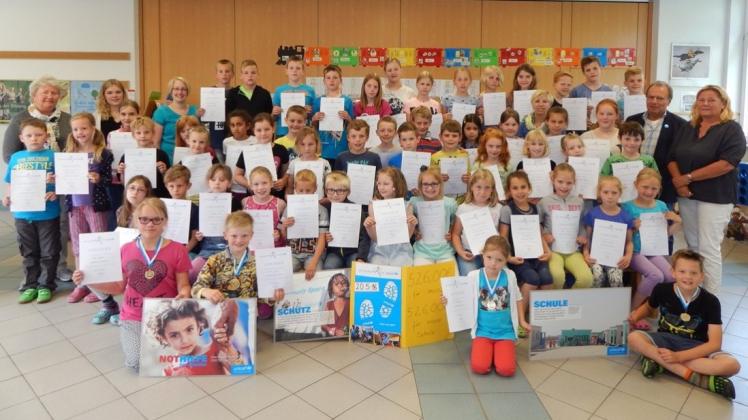 Über den Erlös des Spendenlaufes erfreuten sich Gerd Bartinger, Leiter der UNICEF-Arbeitsgruppe Ostfriesland (rechts), das Lehrerkollegium sowie die Schüler der Grundschule Walchum. 