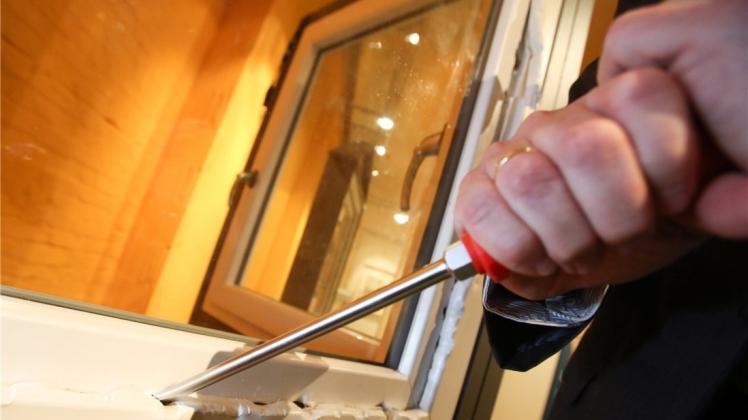 Ein Kriminalbeamter demonstriert, wie ein ungesichertes Fenster mit einem Schraubenzieher aufgebrochen werden kann. 