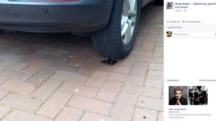 Unbekannte haben in Papenburg eine Kunststoffplatte, in der sich zwei Nägel befanden, hinter den Hinterreifen eines Autos gelegt. Screenshot: NOZ/Facebook