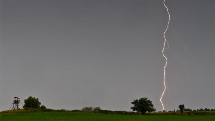 Ein Blitz leuchtet über einem Feld nahe Sieversdorf im Landkreis Oder-Spree (Brandenburg). 