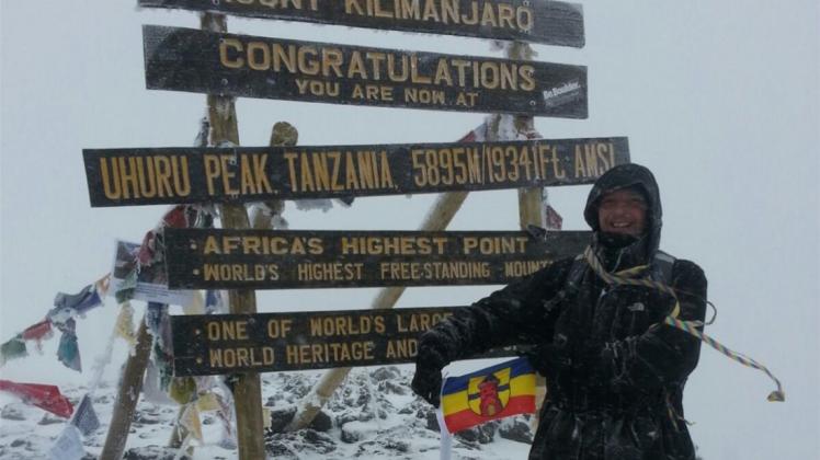 Jörn Stilke zeigt auf dem Gipfel des Kilimandscharos die Fahne Delmenhorsts. 