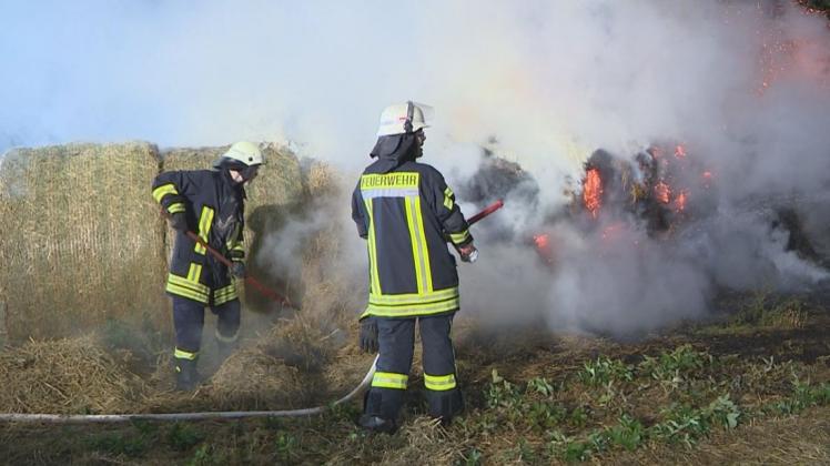 Feuerwehrleute aus Ganderkesee und Havekost löschen die brennenden Strohballen an der Bundesstraße 213 in Höhe Schlutter. 