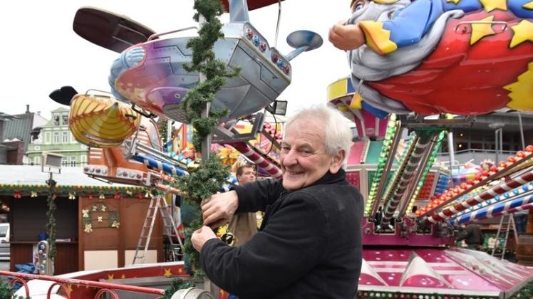 Siegfried Weber dekoriert das Kinder-Flug-Karussell. Bis auf ein paar Weihnachtskugeln ist es schon bereit, um zur Delmenhorster Weihnachtsmarkt-Eröffnung am Mittwoch abzuheben. 