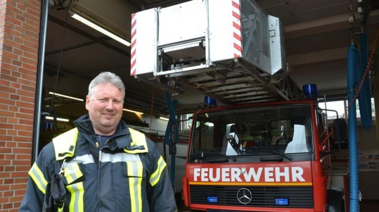 Der stellvertretende Ortsbrandmeister Matthias Torunski steht vor der Fahrzeughalle des Ganderkeseer Feuerwehrhauses, hinter ihm die Ersatzdrehleiter der Ortsfeuerwehr. 