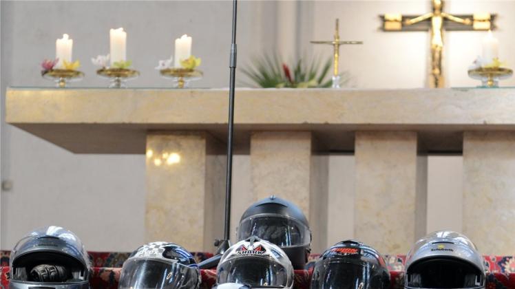 Motorradhelme in Form eines Kreuzes erinnern wie hier 2013 in einer Berliner Kirche auf den Altarstufen an verunglückte Biker. 
