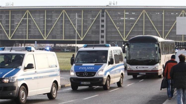 Polizeifahrzeuge begleiten einen Bus mit abgelehnten Asylbewerbern zum Flughafen Leipzig-Halle. 