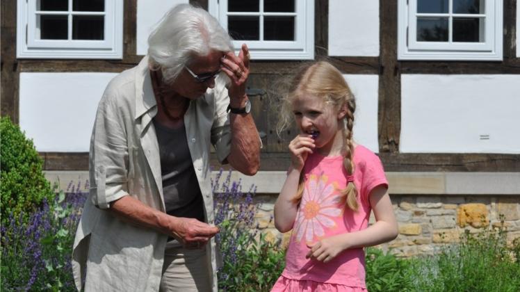 Die Gurkenkrautblüte kann man essen, erklärt Antje Deppe der siebenjährigen Emilia. 