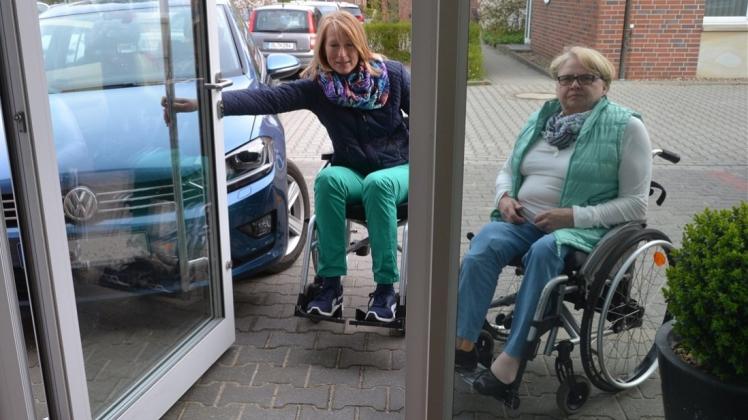 Barrierefreiheit missachtet: Inga Marbach (links) und Doris Josquin, ASG Ganderkesee, quälen sich in Ganderkesee durch eine Tür, die nach außen aufschwingt und auch noch von einem geparkten Auto blockiert wird. 