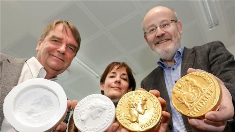 Das Varusschlacht-Museum kooperiert mit der Hochschule Osnabrück, die die in Kalkriese gefundenen römischen Goldmünzen in 3D nachdruckt. Das Ergebnis halten Laborleiter Professor Thomas Derhake, Grafikerin Gabriele Dlubat und Museumschef Joseph Rottmann in den Händen. 
