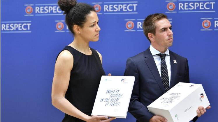 Die frühere Nationalspielerin und DFB-Integrationsbotschafterin Celia Sasic und DFB-Ehrenspielführer Philipp Lahm halten die Bewerbungsunterlagen für die EM 2024 in den Händen.
