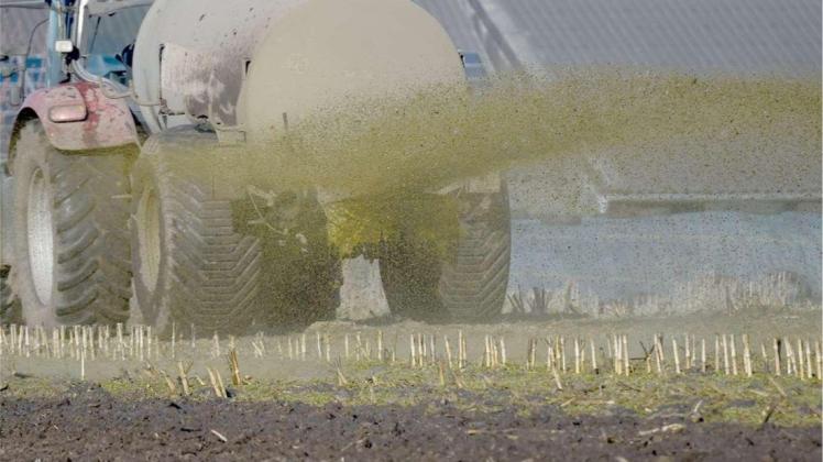 Ein Traktor beim Ausbringen von Gülle auf einem Acker. Symbolbild: Carsten Rehder/dpa