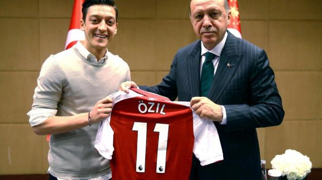 Recep Tayyip Erdogan, Staatspräsident der Türkei, hält zusammen mit Mesut Özil, Spieler beim englischen Premier League Verein FC Arsenal, ein Trikot von Özil. Foto: Uncredited/Pool Presdential Press Service/AP/dpa