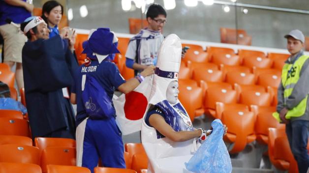 Mit Mülltüten bewaffnet machten sich japanische Fans nach Spielen an die Arbeit. Foto: dpa/kyodo