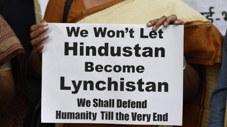 Ein Mitglied der "All India Students Association" protestiert mit einem Plakat gegen die Mob-Angriffe im Land. Foto: imago/Hindustan Times