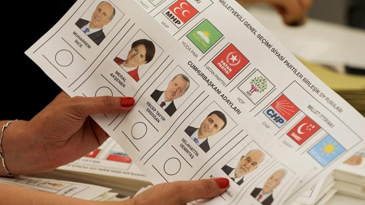 Ein Wahlhelferin hält im türkischen Generalkonsulat einen Stimmzettel in der Hand. Foto: dpa
