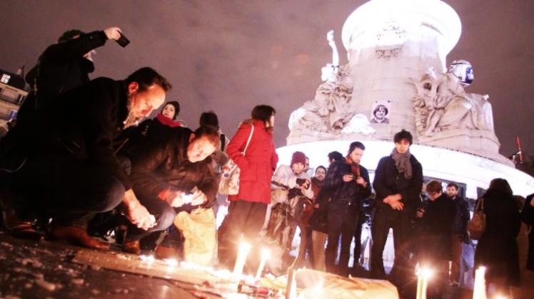 Menschen trauern und demonstrieren in Paris (Ile-de-France) auf dem Place de la République nach dem Anschlag auf die Redaktionsräume von „Charlie Hebdo“ und zünden Kerzen an. 