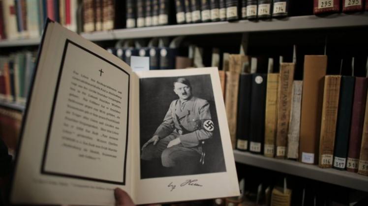 Eine Mitarbeiterin der Universitätsbibliothek zeigt in Köln „Das Deutsche Führerlexikon“, ein nicht frei ausleihbares Buch (Remota). 