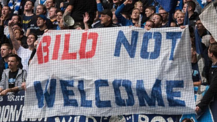 Fans des Karlsruher SC halten ein Transparent mit der Aufschrift „BILD not welcome“ hoch. 