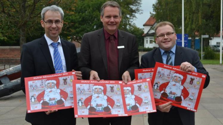 Lothar Wimmelmeier von der Gemeinde (Mitte) sowie Rainer Troue (links) und Henning Sittauer als Vertreter der Interessengemeinschaften stellen den neuen Stuhrer Adventskalender vor. 