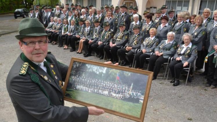 Freut sich auf die „Geburtstagsfeier“: Schützenvereinsvorsitzender Thomas Chmielewski mit dem Bild vom 100. Jubiläum. 