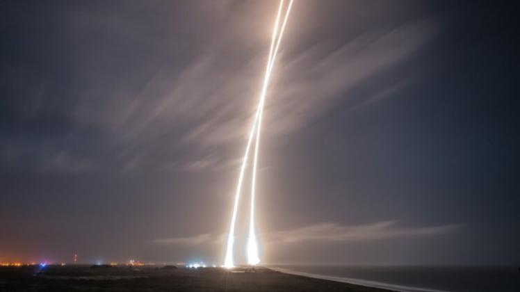 Auf diesem Bild mit Langzeitbelichtung sind die Start- und Landeflugbahnen der Falcon-9-Rakete bei Cape Canaveral zu sehen. 