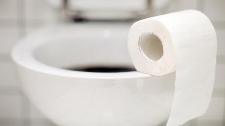 Eine Rolle Toilettenpapier liegt auf einer Herrentoilette. 