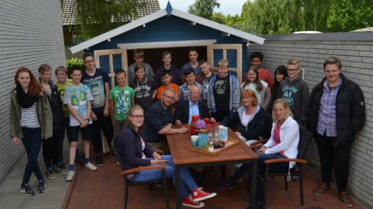 Rotarier Gerold Sprung (am Tisch in der Mitte) hat mit den Jugendlichen das Kaffeepott-Gartenhaus eingeweiht. 