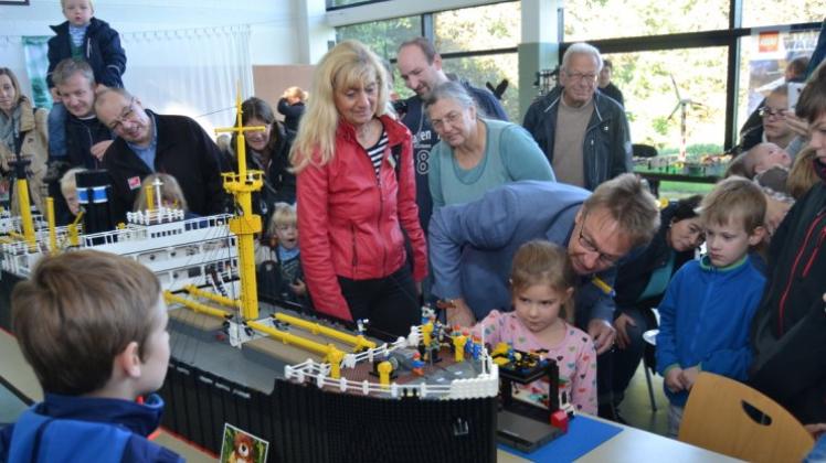 Ganz aus Lego: Nori tauft den Stückgutfrachter-Nachbau „Horn“, assistiert von bfw-Leiter Hubert Barlsen. Die stellvertretende Bürgermeisterin Christel Zießler und Organisatorin Marit Menninga schauen ihnen über die Schulter. 
