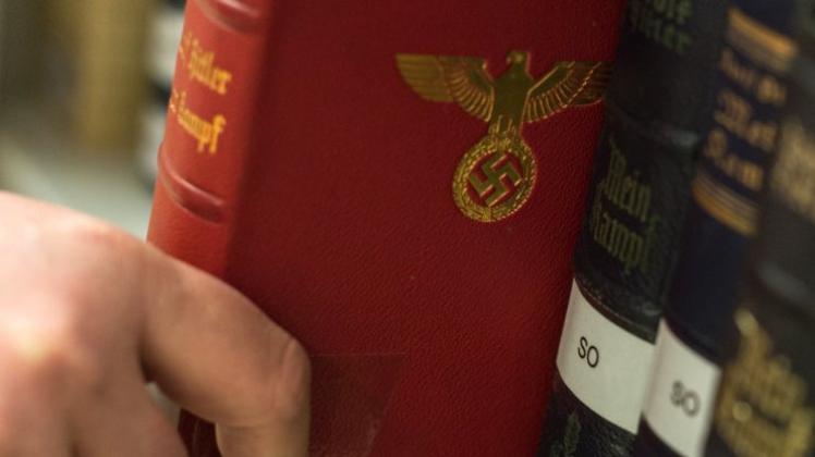 Nach 1945 nicht wieder gedruckt: Bibliotheksleiter Schlögl zieht am in den Räumen vom Institut für Zeitgeschichte in München (Bayern) eine gebundene Ausgabe von Adolf Hitlers „Mein Kampf“ aus einem Bücherregal mit zahlreichen Ausgaben des Buches. 