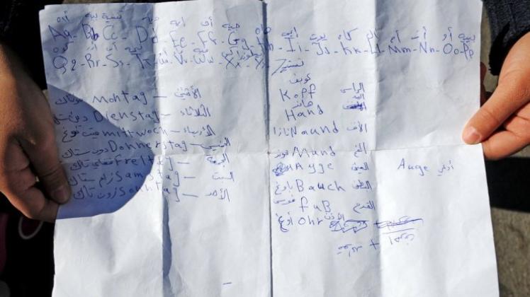 Sprache als ein Schlüssel zur Integration: Ein syrisches Mädchen zeigt auf einem Blatt Papier, was es an deutschen Wörtern gelernt hat. 