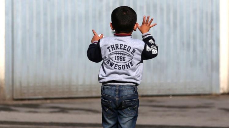 Ein Flüchtlingskind spielt vor einer Garage auf dem Gelände der Erstaufnahmeeinrichtung in Dortmund. Symbolbild: Ina Fassbender/dpa