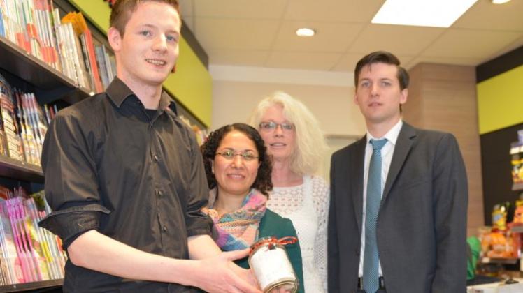 In seinem Kiosk in Lingen hält Julius Frilling das Glasgefäß mit Bons hoch für den „Aufgeschobenen Kaffee“. Weiter auf dem Bild: Medina Atalan, Iris Oldekamp und Andreas Kröger vom SPD-Ortsverein Lingen (von links). 