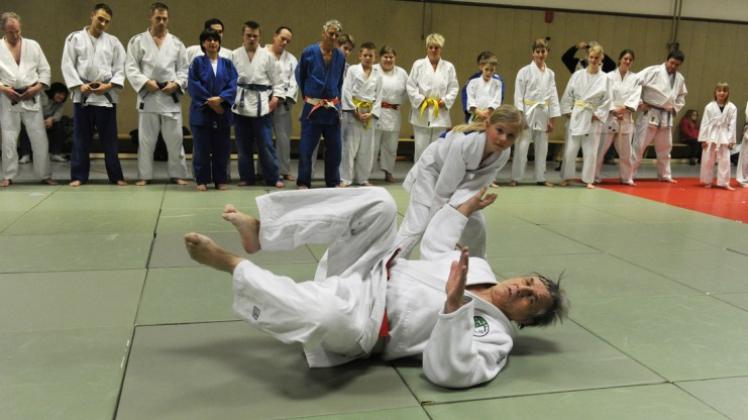 Kein Problem: Die junge Judoka Kara Richter legt Altmeister Klaus Glahn auf die Matte. Im Hintergrund schaut Harry Utzat (blauer Anzug in der Mitte) ganz genau hin. 