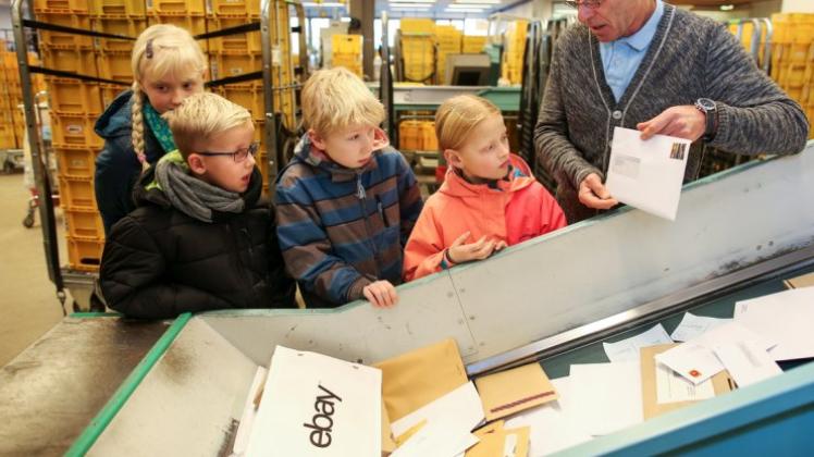 Hans Radzuweit, der stellvertretende Leiter des Briefzentrums Osnabrück, zeigte den Kindern bei der Adventstürchen-Führung die großen Sortiermaschinen,. 