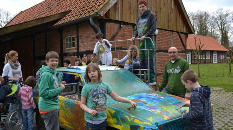 Voller Enthusiasmus bei der Arbeit: Die jungen Bewohner des Kinder- und Jugendhauses bemalen ein Auto für ein Stockcar-Rennen. 