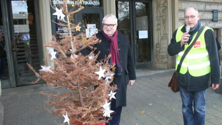 Henning Lühr, Staatsrat bei der Bremer Finanzsenatorin, nahm einen modernden Weihnachtsbaum für sein Ressort an. Rechts im Bild: Burghardt Radtke. 