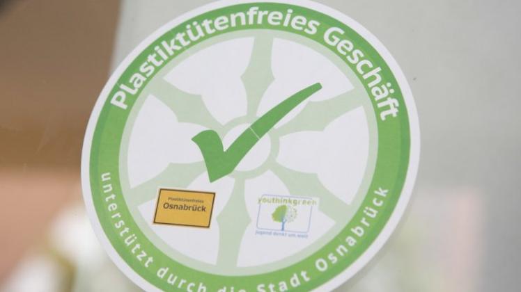 Das Osnabrücker Emblem „Plastiktütenfreies Geschäft“ zeigt, grün umrahmt, unter anderem das aus dem Stadtwappen bekannte Rad sowie in der Mitte ein grünes Häkchen. 