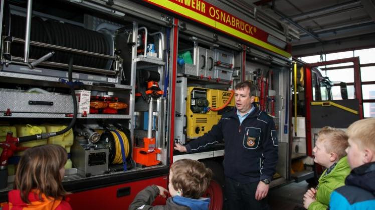 #Adventstürchen - Ein Feuerwehrmann führt Kinder am 02.12.2015 hinter die Kulissen der Berufsfeuerwehr Osnabrück ein. 