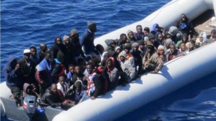 Flüchtlinge mit ihrem Schlauchboot in unmittelbarer Nähe des Frachtschiffes «OOC Cougar» auf dem Mittelmeer. 