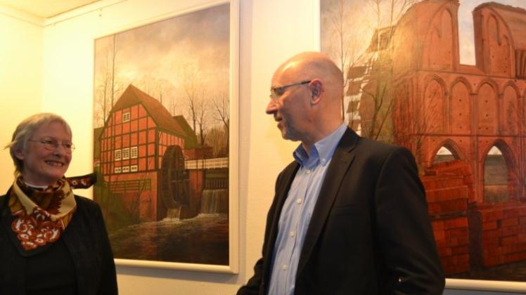 Wassermühle, Klosterruine und (nicht im Bild) die Sankt-Elisabeth-Kirche: Birgit Ganteföhr und Bürgermeister Holger Lebedinzew vor den Kunstwerken im Saal des Rathauses Hude. Wassermühle, Klosterruine und (nicht im Bild) die Sankt-Elisabeth-Kirche: Birgit Ganteföhr und Bürgermeister Holger Lebedinzew vor den Kunstwerken im Saal des Rathauses Hude.
