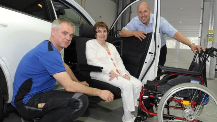 Werkstattmeister Andreas Zelt (links) und ASP-Firmenchef Dirk Poweleit assistieren Kirsten Tobis beim Ausprobieren des schwenkbaren Beifahrersitzes. 