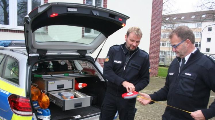 Alles dabei? Teamleiter Sascha Schütte (links) und der stellvertretende Dienststellenleiter Reinhard Lueßen checken ein Maßband, das zur Ausrüstung der Streifenwagen gehört. 