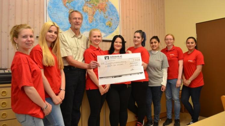 Die Schülerinnen der Schülerfirma Küchenzauber haben 570 Euro an Dr. Hans-Christian Schröder von der Stiftung steps for children übergeben. 