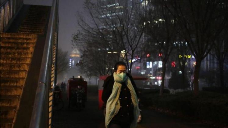 Eine Frau in Peking trägt zum Schutz eine Atemschutzmaske. 