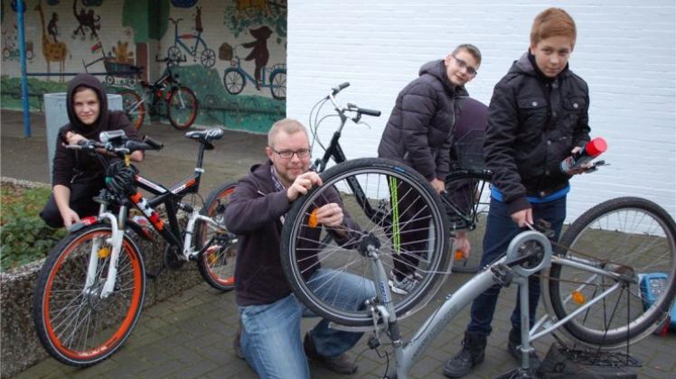 Jugendtreff-Leiter Hannes Drygala (Mitte) hilft René, Luca und Dennis (v. links,alle zwölf Jahre alt) bei der Reparatur ihrer Fahrräder. 