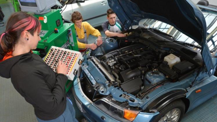 Auszubildende des KfZ-Handwerks diagnostizieren eine Fehlerquelle an einem Fahrzeug. 