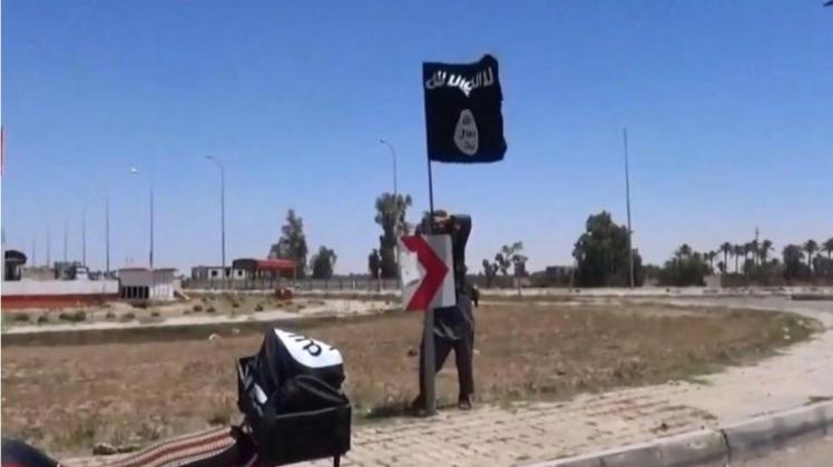 In einem Dschihadisten-Video sieht man einen IS-Kämpfer, der angeblich in Ramadi die Flagge der Terrormiliz hisst. Foto: Aamaq Media
