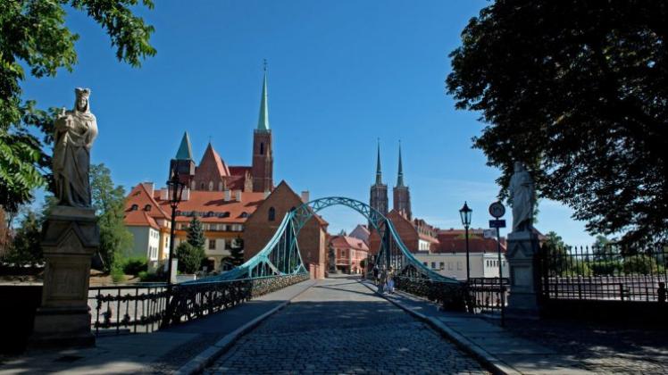 Breslau bietet viel Geschichte: Die Tumski Brücke zur Dominsel mit der Kreuzkirche (l) und dem Dom, der Kathedrale Sankt Johannes der Täufer. 