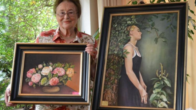 Ingeborg Stolle und zwei ihrer liebsten Bilder, ein Rosen-Motiv und ein Bildnis ihrer Nichte im Garten in Stenum. 
