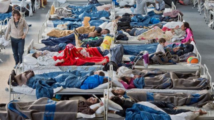 Flüchtlinge in einer Notunterkunft - hier in Hessen. Niedersachsen verpflichtet jetzt Kommunen, Flüchtlinge aufzunehmen. 